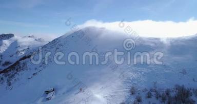 前方空中冬季雪山山顶滑雪道度假村与滑雪者滑雪。 晴天，雾蒙蒙的云.. 福克